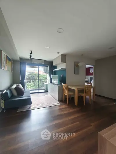 Spacious living room with open kitchen and balcony view in modern apartment