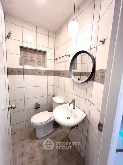 Compact bathroom with modern fixtures and stylish tile design, perfect for urban living.