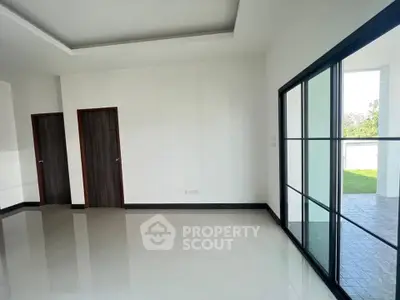 Spacious modern living room with large windows and outdoor access, perfect for natural light lovers.