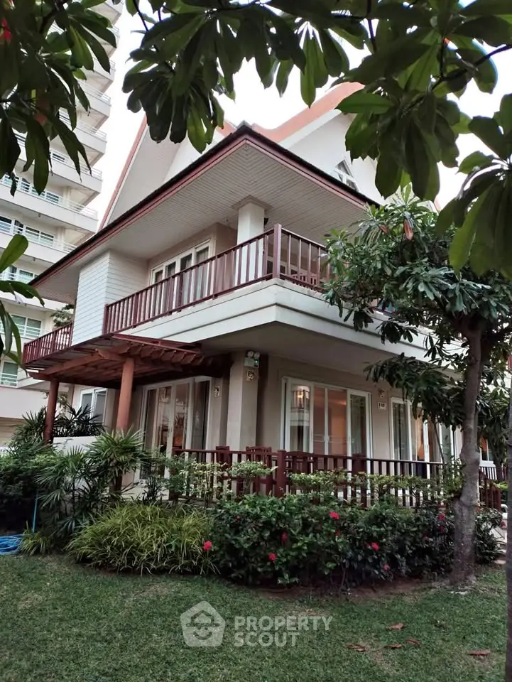 Charming two-story house with lush garden and spacious balcony, perfect for family living in a serene neighborhood.