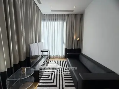 Modern living room with sleek black sofa and stylish geometric rug