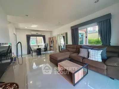Spacious modern living room with large windows and elegant furnishings in a stylish home.