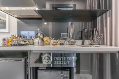 Modern kitchen with sleek appliances and stylish countertop in contemporary apartment.