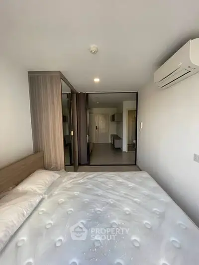 Modern bedroom with air conditioning and stylish wardrobe in a contemporary apartment.