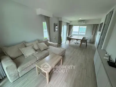 Spacious modern living room with elegant dining area and natural light.