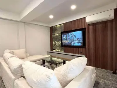 Modern living room with plush white sofas and stylish wall paneling