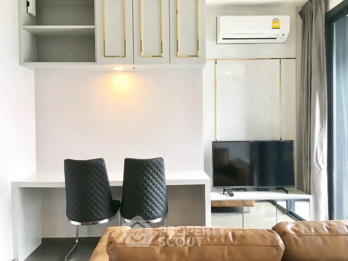 Modern living room with sleek furniture and built-in storage, featuring a cozy seating area and wall-mounted TV.