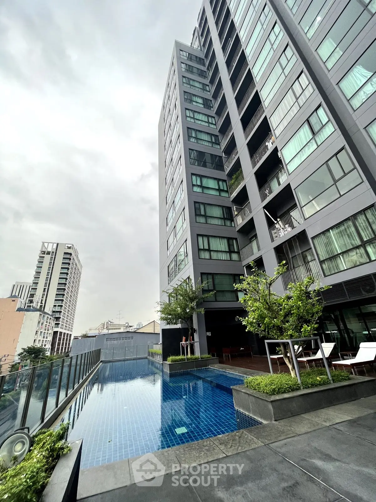 Modern high-rise building with rooftop pool and city view
