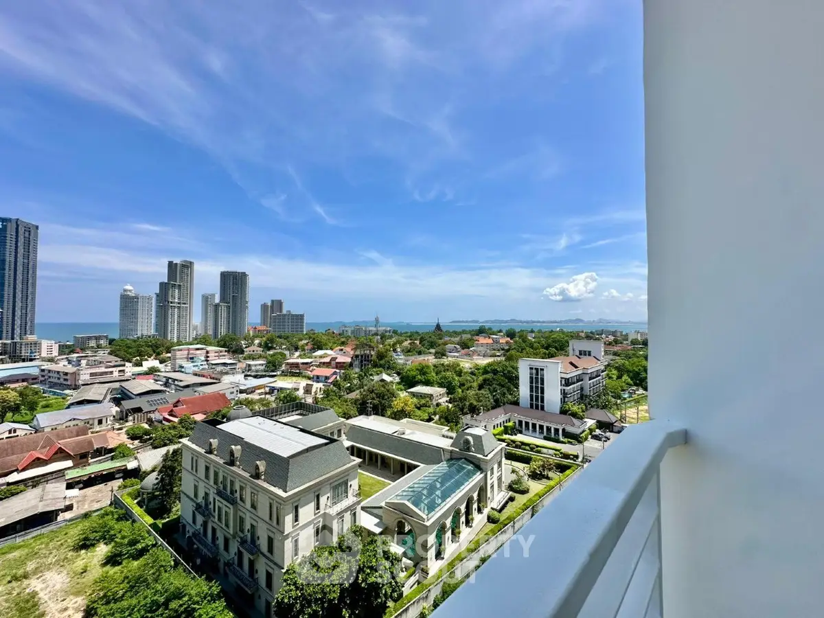 Stunning cityscape view from a high-rise balcony overlooking urban skyline and distant ocean.