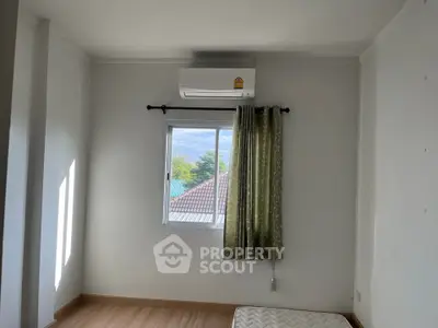 Bright bedroom with air conditioning and window view, perfect for comfortable living.