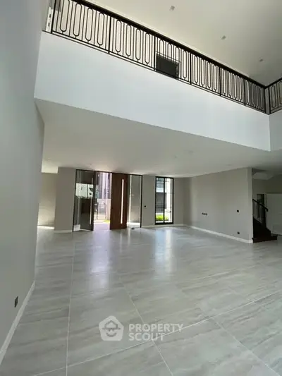 Spacious modern living room with high ceilings and large windows for natural light.