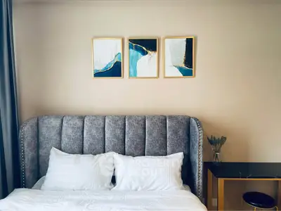 Elegant bedroom with plush headboard and modern art decor