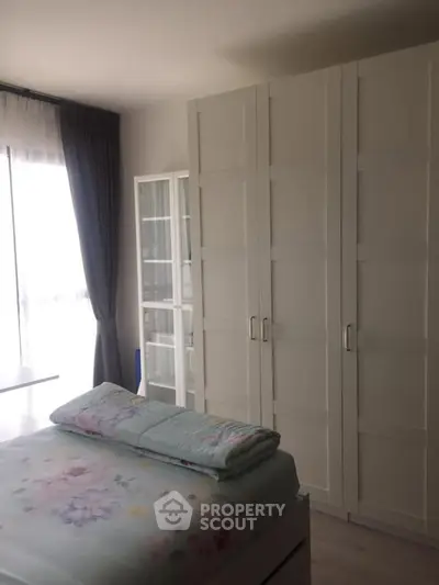 Cozy bedroom with large wardrobe and natural light from window