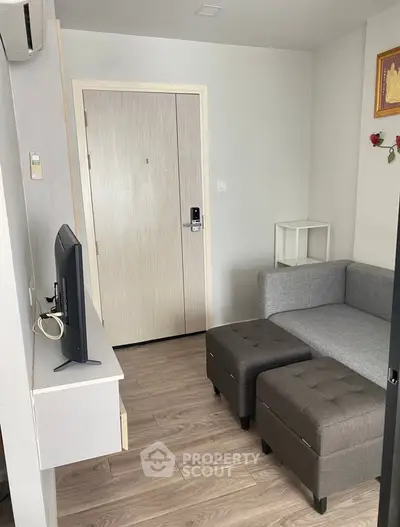 Cozy living room with modern gray sofa and wall-mounted TV, perfect for relaxation.