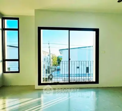 Bright empty room with large window and balcony view in modern apartment.