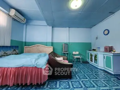 Spacious bedroom with vibrant blue decor and cozy furnishings