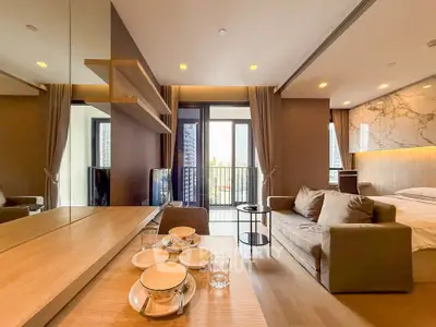 Modern open-plan living room with cozy sofa and elegant decor, featuring a small balcony view.