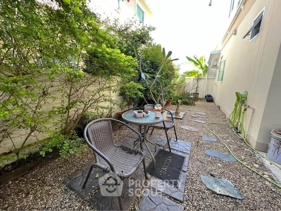 Charming garden patio with cozy seating and lush greenery, perfect for relaxation and outdoor enjoyment.