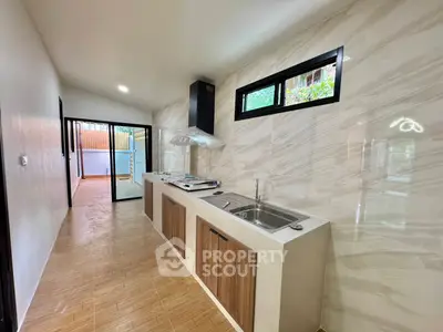 Modern kitchen with sleek design and open layout, featuring stylish cabinetry and large windows.