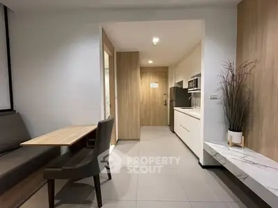 Modern kitchen with sleek design and dining area in contemporary apartment.
