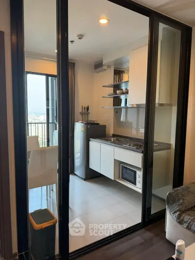 Modern kitchen with sleek design and balcony view in high-rise apartment