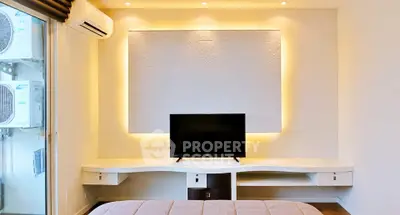 Modern bedroom with stylish lighting and wall-mounted TV, featuring air conditioning unit and cozy ambiance.