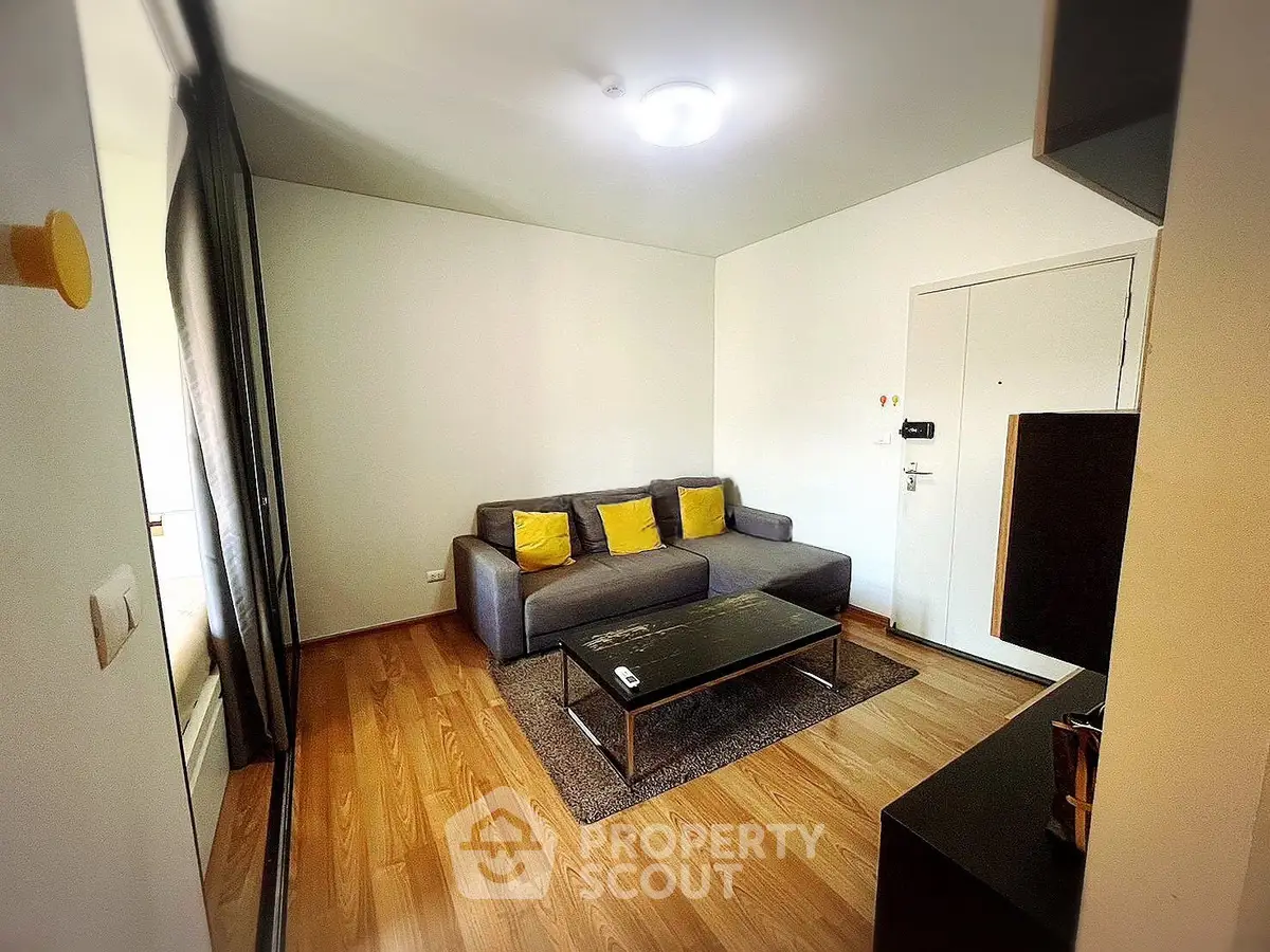 Cozy living room with modern sofa and wooden flooring in a stylish apartment.