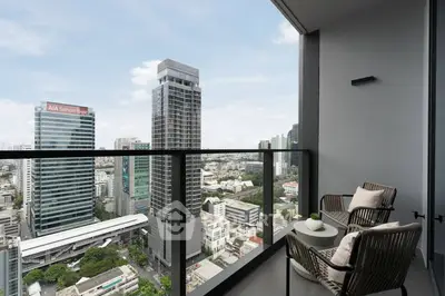 Stunning city view from a modern balcony with cozy seating area, perfect for relaxation.