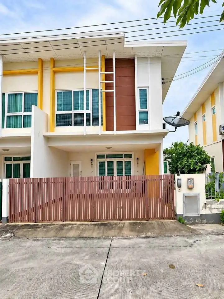 Modern two-story townhouse with unique architectural design and vibrant exterior colors.