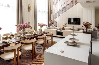 Luxurious open-plan living and dining area with elegant decor and high ceilings.