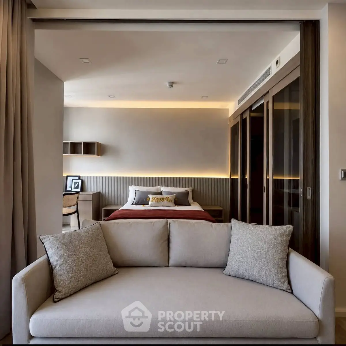 Modern open-plan living room and bedroom with stylish decor and neutral tones.