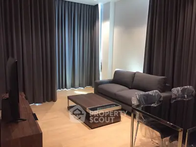 Modern living room with sleek furniture and floor-to-ceiling curtains