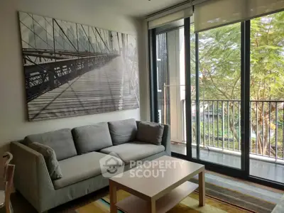 Modern living room with large window and balcony view, featuring a stylish sofa and artwork.