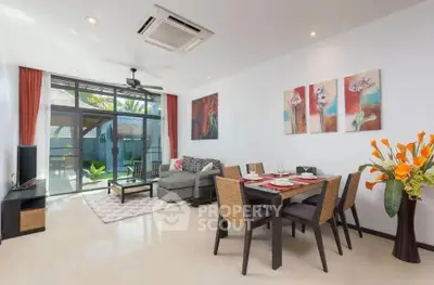 Spacious living room with modern decor and large windows opening to a garden view.