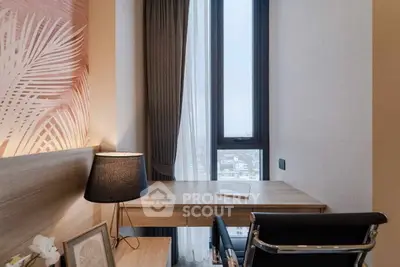 Modern study room with sleek desk, stylish lamp, and large window offering city views.