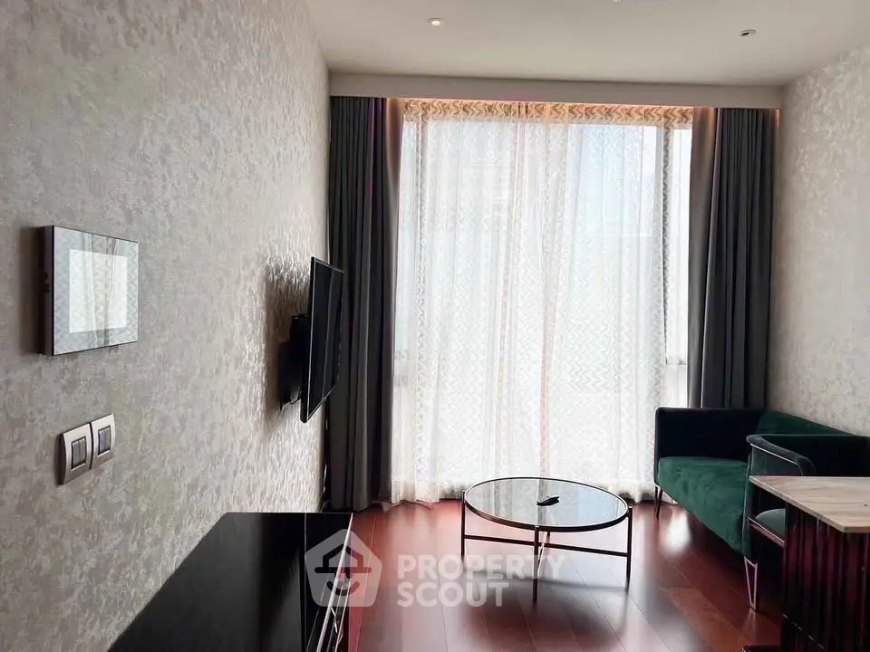 Modern living room with elegant decor and large window, featuring a wall-mounted TV and stylish furniture.