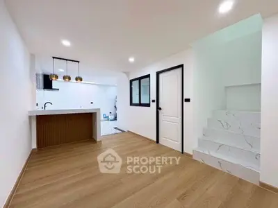 Modern open-plan living space with stylish kitchen and elegant staircase