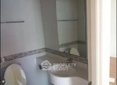 Modern bathroom with sleek sink and large mirror in contemporary home.