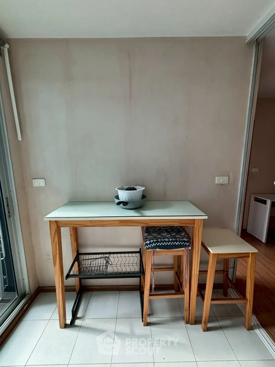 Cozy dining nook with wooden table and stools, perfect for small spaces.