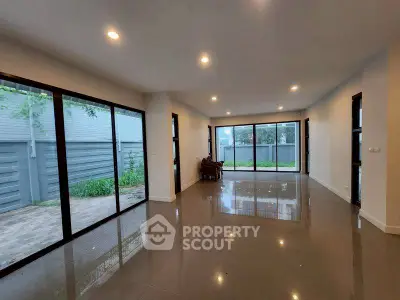 Spacious modern living room with large windows and glossy floors