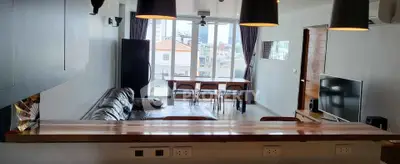 Modern living room with open layout and stylish furniture, featuring a large window view.