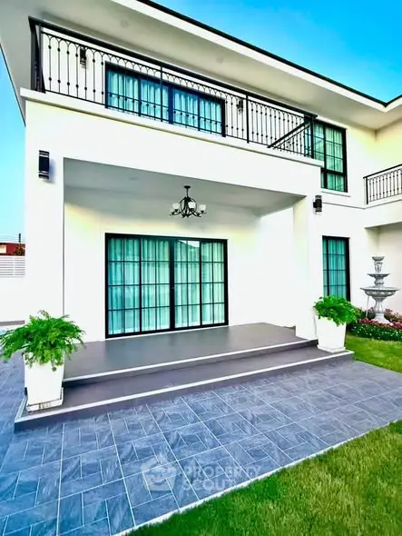 Stunning modern home exterior with elegant balcony and lush garden