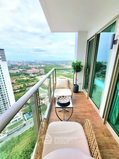 Luxurious high-rise balcony with stunning city view and cozy seating area.