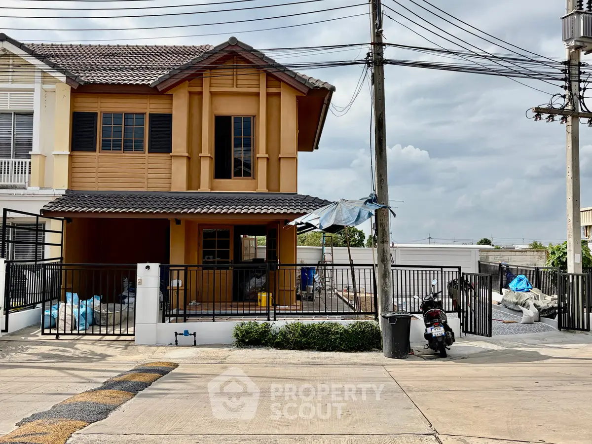 Charming two-story house with a fenced yard and modern design in a suburban neighborhood.