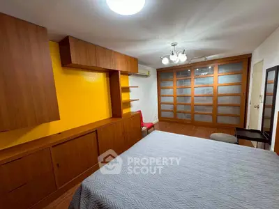 Spacious bedroom with modern wooden cabinetry and large closet doors