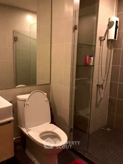 Modern bathroom with glass shower and sleek fixtures in contemporary apartment.