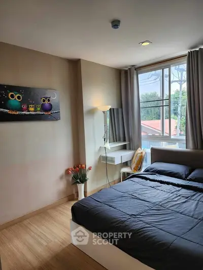Cozy bedroom with large window and modern decor, featuring a comfortable bed and stylish artwork.