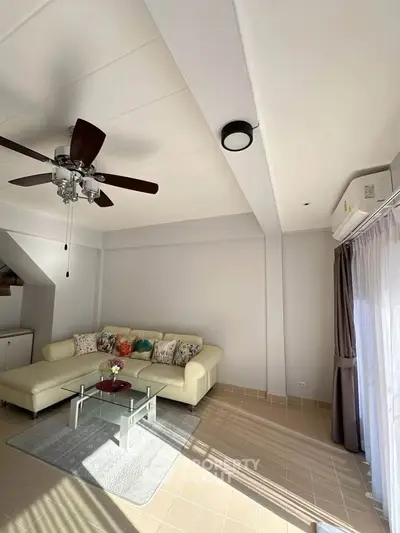 Bright living room with modern ceiling fan and cozy sofa in a stylish home