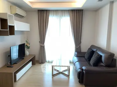 Modern living room with sleek furniture and natural light, perfect for relaxation and entertainment.