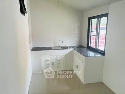 Modern minimalist kitchen with sleek countertops and ample natural light.